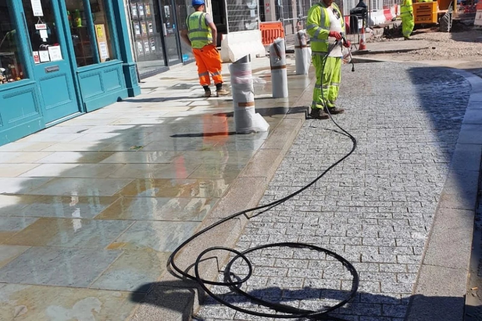 Large format stone flags and granite setts newly laid and washed down on a high street